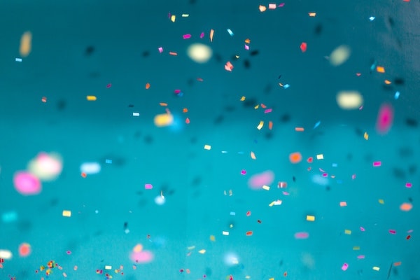 Confettis falling over blue wall